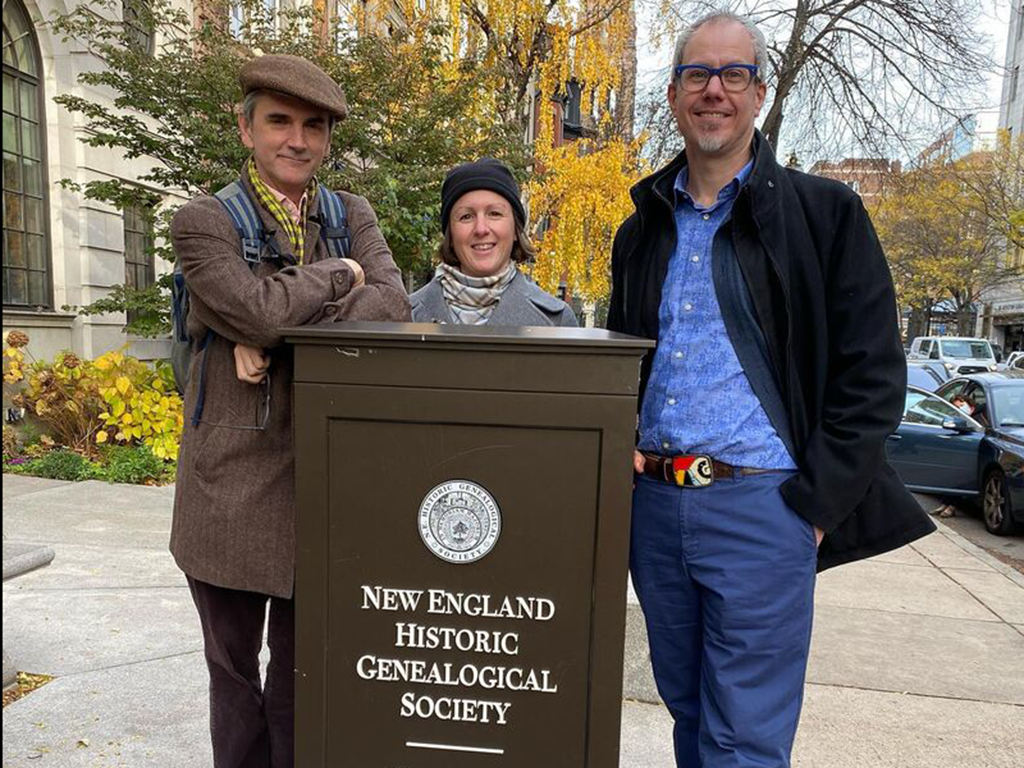 L-R: Ed, Annie, and Jim stand smiling in front of a sign for New England Historic Genealogical Society